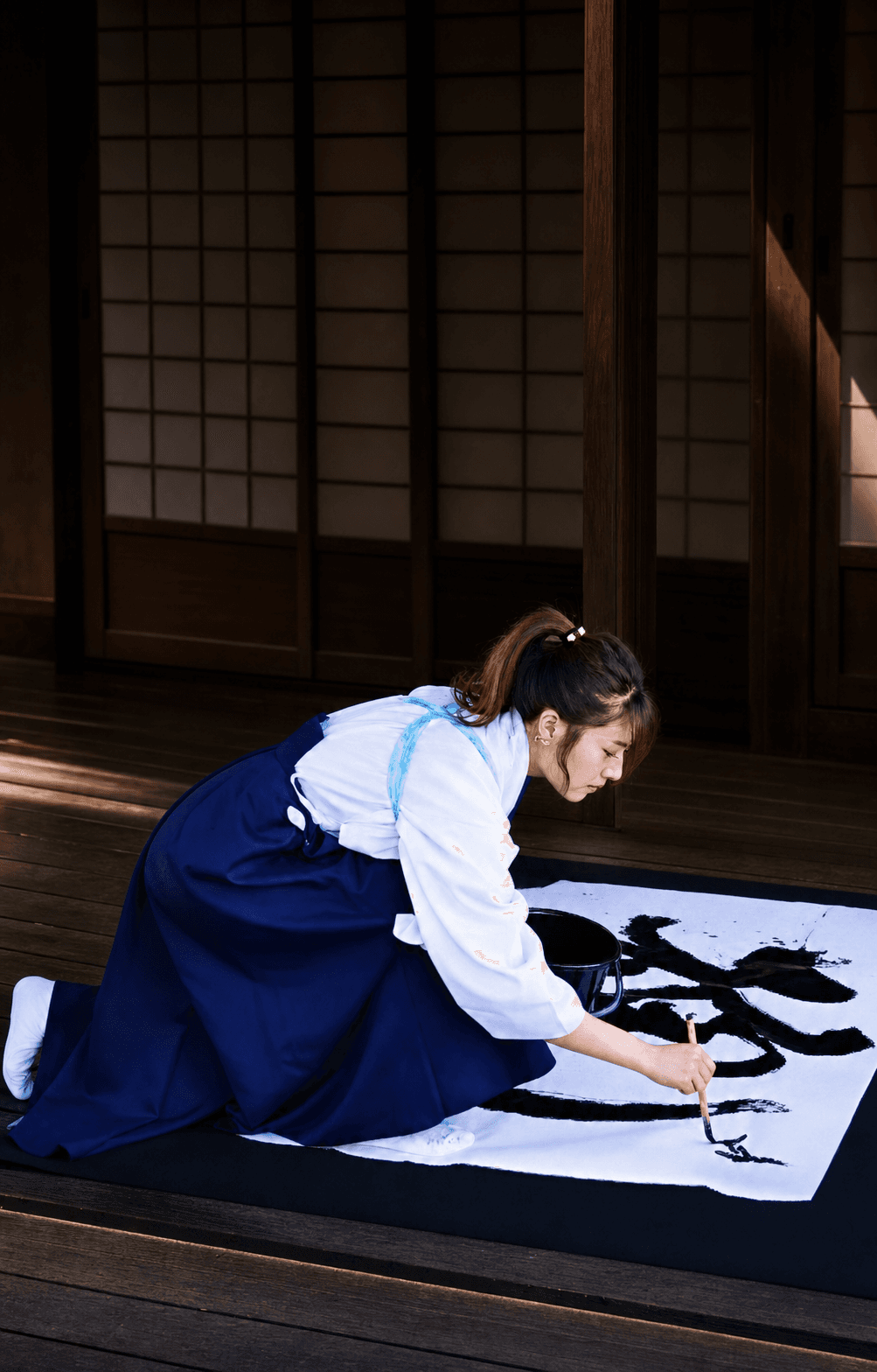 Calligrapher creating a large-format work during a live shodo performance