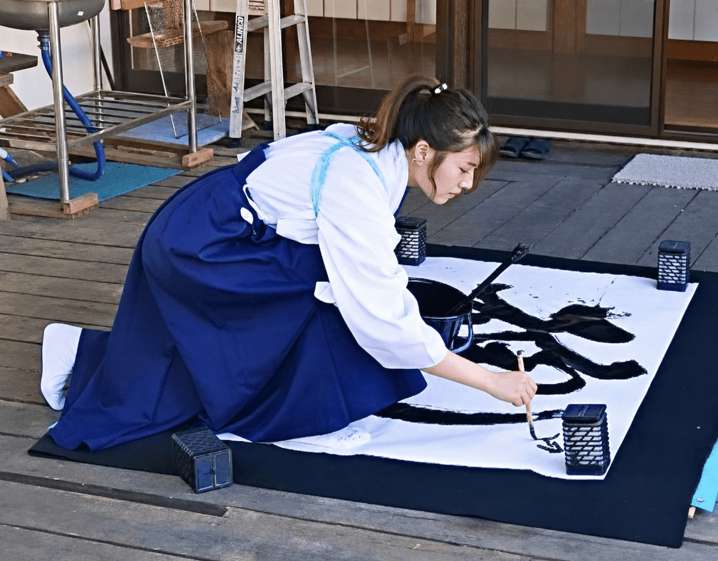 Calligrapher creating a large-format shodo work with a brush